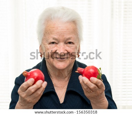 Portrait of old woman with pomegranates in her hands