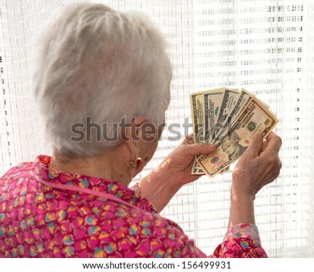 Portrait of  old woman holding money in hands