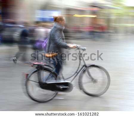 Cyclist in motion going down the street . Intentional motion blur