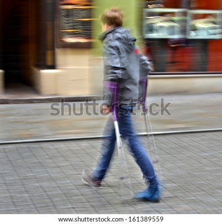 Injured young man on crutches,  intentional motion blur