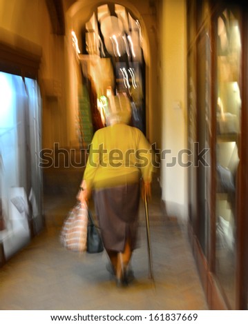 Old woman with a cane. Intentional motion blur