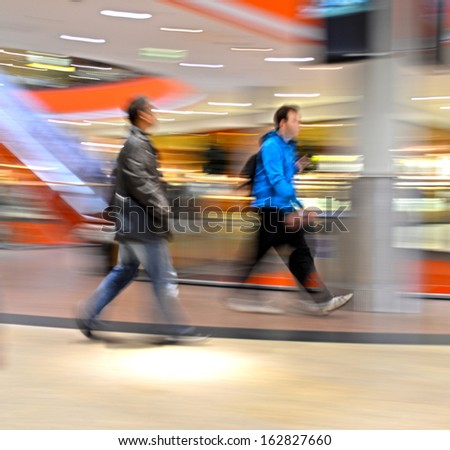 People silhouettes in shopping mall in motion blur
