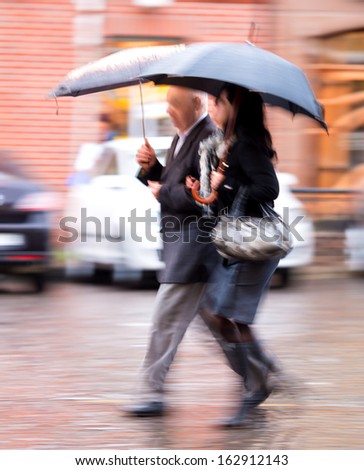 People walking in the street on a rainy day in motion blur