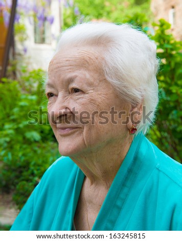Old smiling woman on nature background