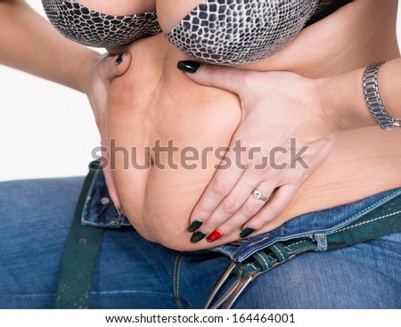Plump woman pinching her fat tummy