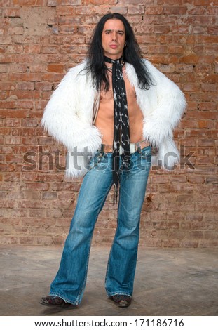 Young man with long hair in fur coat