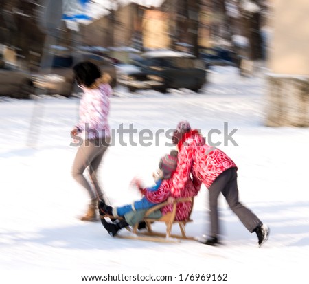 Family walking in the street in wintertime in motion blur