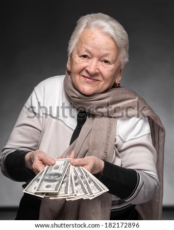 Smiling old woman holding money in hands
