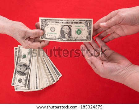 Hand handing over money to another hand on a red background