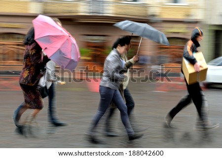 Group of people walking down the street in rainy day in motion blur