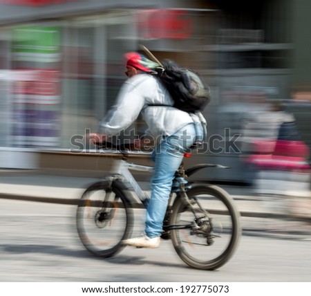 Cyclist in motion riding down the street . Intentional motion blur