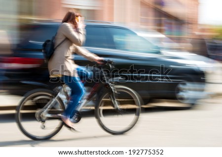 Cyclist in motion riding down the street . Intentional motion blur