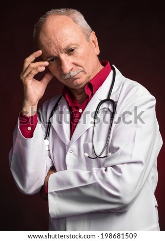 Medical doctor with stethoscope on a dark red  background