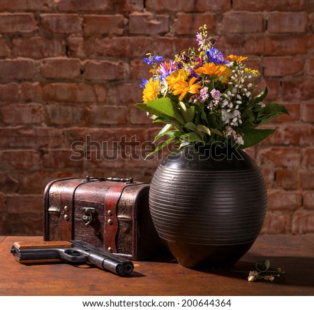 Still life with field flowers, old box and gun