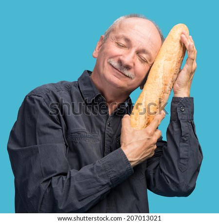 Happy senior man with fresh baguette on a blue background