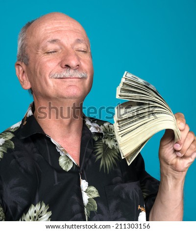 Lucky old man holding dollar bills on a blue background