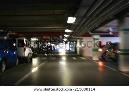 Parking garage, underground interior with a few parked cars. Intentional motion blur