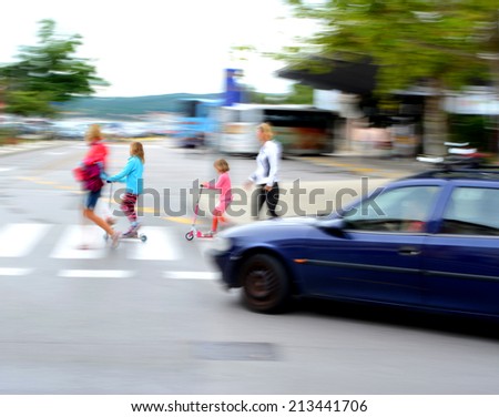 Dangerous city traffic situation with children, parents and car in motion blur