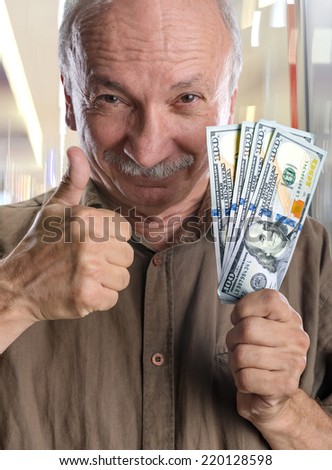 Lucky elderly man holding dollar bills