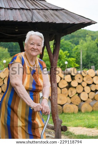 Smiling old woman with a cane in the garden