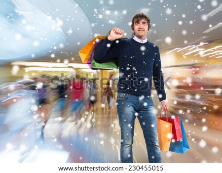 Smiling man with shopping bags at shopping mall. Christmas and holidays concept