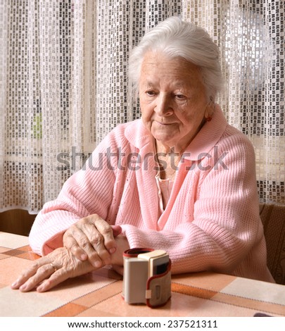 Sad old woman and blood pressure measuring