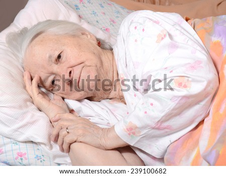 Sick old woman lying at bed