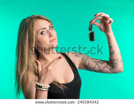 Woman holding car keys on a green background