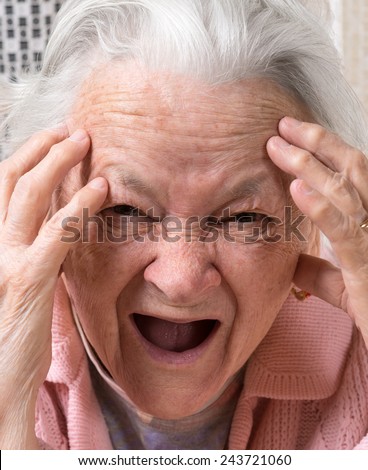 Closeup portrait of scared shouting old woman at home. Negative emotions