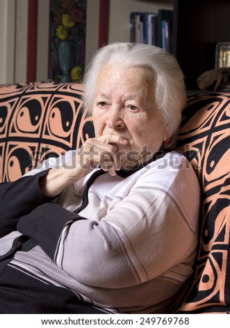 Portrait of old sad woman at home