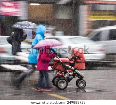 People on the streets of the city in a snowy day in motion blur