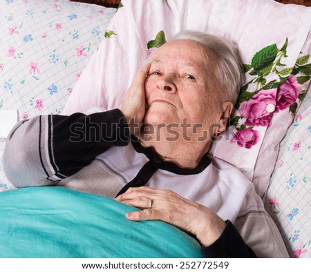 Sick old woman lying in bed
