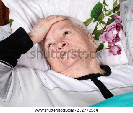 Sick old woman lying in bed