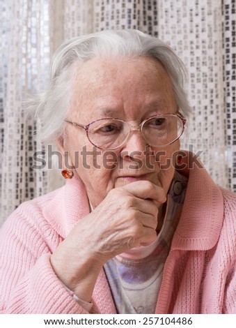 Portrait of old sad woman at home