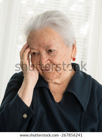 Old sad woman suffering from headache