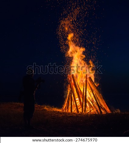 Big bonfire against dark night sky. Fire flames on black background