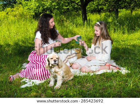 Mother and daughter drinking water in the park