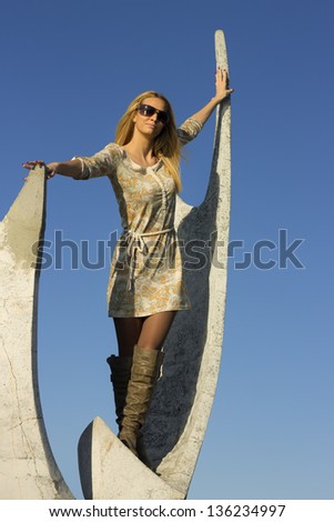 Beautiful girl on a monument, young fresh woman, face, long hair . Lake Palic in Vojvodina, Serbia.