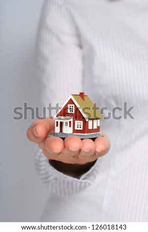 Real estate cocnept. Small house in female hands.