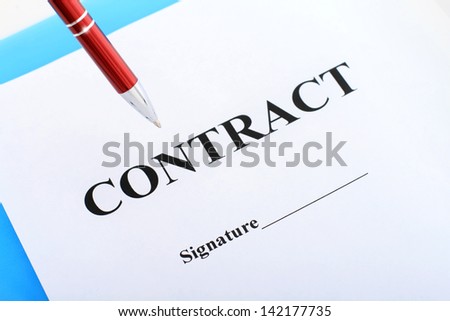 Red pen and contract on table.