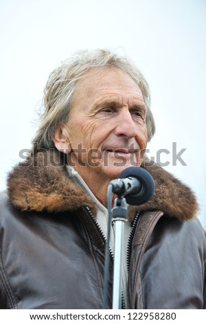 PAGHAM, WEST SUSSEX, ENGLAND - DECEMBER 26 2012: Derek Bell hands out awards at the Pagham Pram Race on boxing day, December 26, 2012