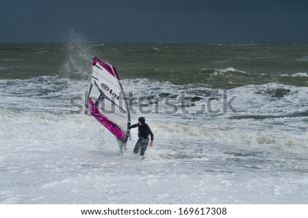 PAGHAM, WEST SUSSEX, ENGLAND - JANUARY 4: A wind surfer has been pushed ashore in high waves on January 4, 2014. High waves threaten to flood homes and towns as storms batter the UK\'s coastline.