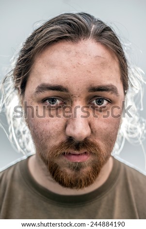 Portrait shot of a long haired man covered in dirt from working on cars