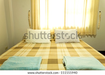 clean comfortable standard bed with orange curtain in the evening, good for relax