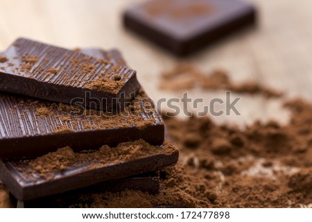 Dark Chocolate with Cocoa on Wooden Table
