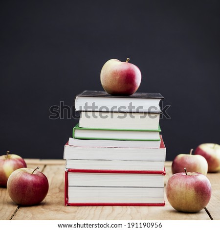 School books with apples on the table