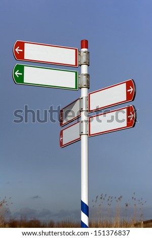 Blank road sign with six signs on pole in red and green pointing in three directions