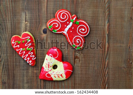 Gingerbread cookie figures with colorful glaze on wooden background.