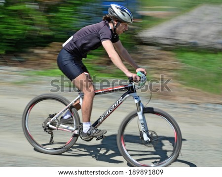 CLUJ-NAPOCA, ROMANIA - APRIL 27, 2014: Unidentified mail bike rider races downhill at \
