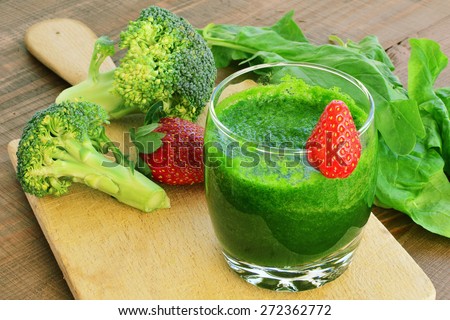Green vegetable smoothie with strawberries. Spinach, broccoli, cucumber smoothie in glass.